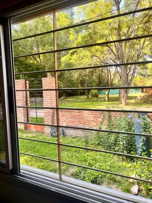 a window with a view of a yard at Las Catitas in Villa Carlos Paz