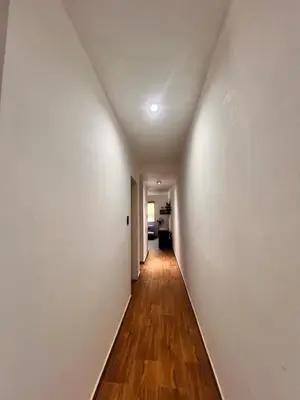 an empty hallway with white walls and wood floors at Las Catitas in Villa Carlos Paz