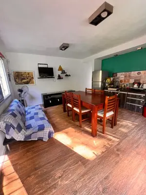 a living room with a wooden table and chairs at Las Catitas in Villa Carlos Paz