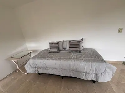 a bedroom with a bed with pillows and a table at Villa Pellegrini in Trapiche