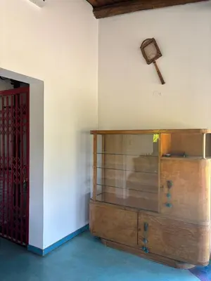 a wooden cabinet in a room with a cross on the wall at Villa Pellegrini in Trapiche
