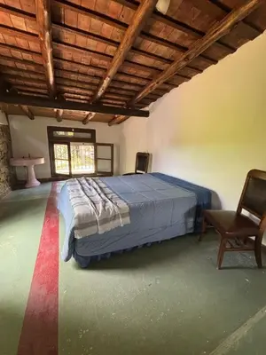 a bedroom with a bed and a chair in a room at Villa Pellegrini in Trapiche