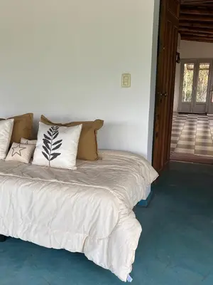a white bed with pillows on it in a room at Villa Pellegrini in Trapiche