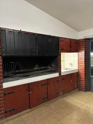 a kitchen with black cabinets and a sink at La casa del Sapo Pepe Carlos Paz in Cordoba