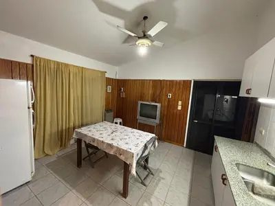 a kitchen with a table and a television in it at La casa del Sapo Pepe Carlos Paz in Cordoba