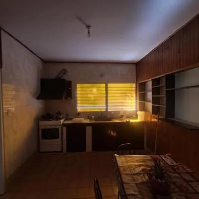 a kitchen with a table and a sink and a window at La Tia in Alta Gracia