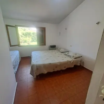 a small bedroom with a bed and a window at La Tia in Alta Gracia