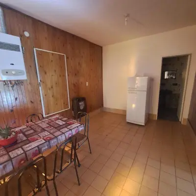 a kitchen with a table and a white refrigerator at La Tia in Alta Gracia