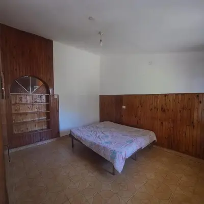 a bedroom with a bed in the corner of a room at La Tia in Alta Gracia
