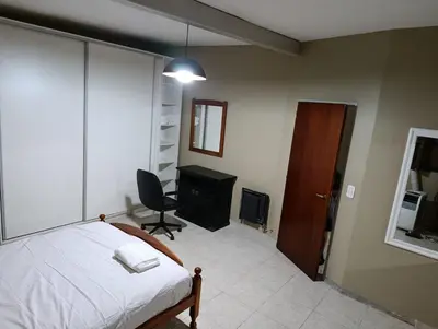 a bedroom with a bed and a desk and a chair at descanso en alta gracia in Alta Gracia