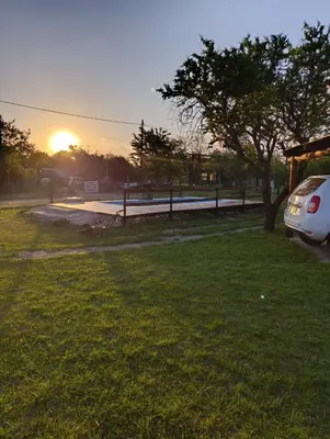 a car parked in a field with the sunset in the background at Cabañas EL VALLE in San Ignacio