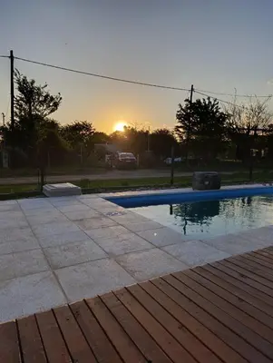 a swimming pool with the sunset in the background at Cabañas EL VALLE in San Ignacio