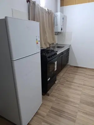 a kitchen with a white refrigerator and a stove at Cabañas EL VALLE in San Ignacio