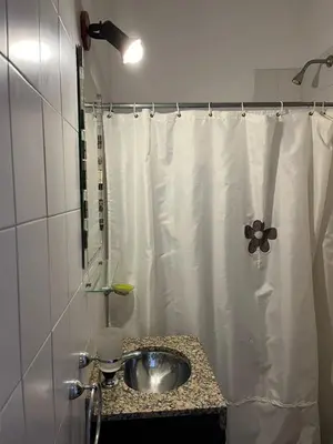a bathroom with a sink and a shower curtain at Departamento espiral in Embalse