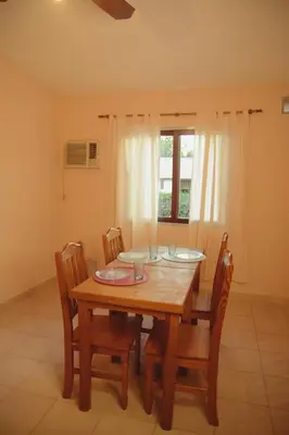 a dining room with a wooden table and chairs at Departamento espiral in Embalse
