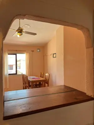 a dining room with a table and chairs and a ceiling fan at Departamento espiral in Embalse