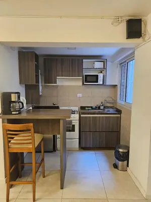 a kitchen with a wooden table and a counter top at NelidaMaria in Cordoba