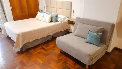 a bedroom with a bed and a chair in it at Kalimera Loft con patio, único en Córdoba Capital in Cordoba