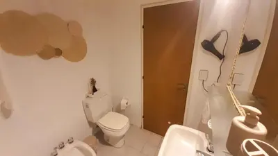 a bathroom with a white toilet and a sink at Kalimera Loft con patio, único en Córdoba Capital in Cordoba