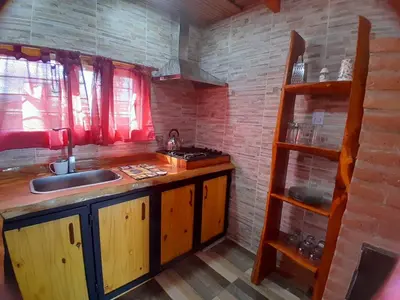 a kitchen with a sink and a counter with a shelf at Cabaña de montaña potrero de garay in Potrero de Garay