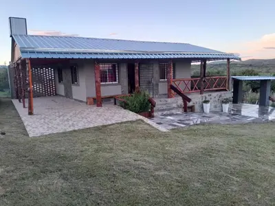 a house with a large patio in front of it at Cabaña de montaña potrero de garay in Potrero de Garay