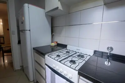 a kitchen with a stove and a refrigerator at Gral Paz Apartment, Pileta Gym y vistas Unicas in Cordoba