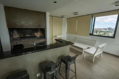 a room with a bar with a fireplace and chairs at Gral Paz Apartment, Pileta Gym y vistas Unicas in Cordoba