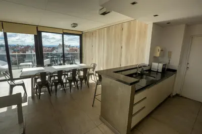 a kitchen and dining room with a table and chairs at Gral Paz Apartment, Pileta Gym y vistas Unicas in Cordoba