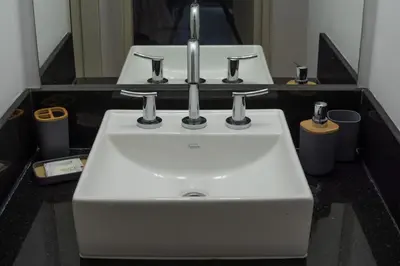 a white sink in a bathroom with two mirrors at Gral Paz Apartment, Pileta Gym y vistas Unicas in Cordoba