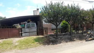 a dog is sticking its head out of a fence at Habitacion en Casa de Olga in Alta Gracia