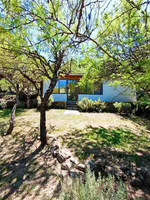 a house with a tree in the yard at Loft de Montaña y Playa VenTeVeo in Atos Pampa
