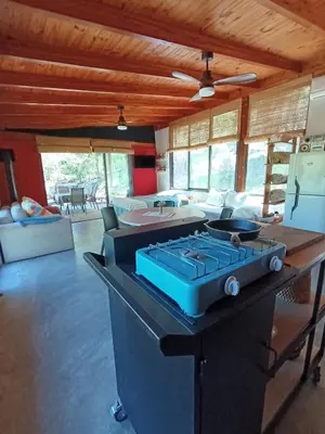 a kitchen with a stove in a living room at Loft de Montaña y Playa VenTeVeo in Atos Pampa
