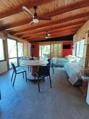 a living room with a table and chairs and a bedroom at Loft de Montaña y Playa VenTeVeo in Atos Pampa