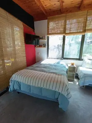 a bedroom with a bed in a room with windows at Loft de Montaña y Playa VenTeVeo in Atos Pampa