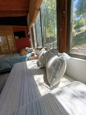 a bed sitting in a room with a window at Loft de Montaña y Playa VenTeVeo in Atos Pampa