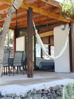 a porch with chairs and a hammock at Loft de Montaña y Playa VenTeVeo in Atos Pampa