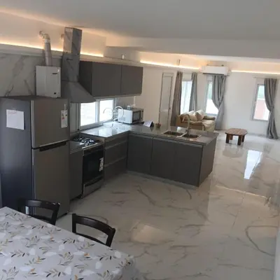 a kitchen with a table and a kitchen with a refrigerator at Ein gutes Haus in Mina Clavero