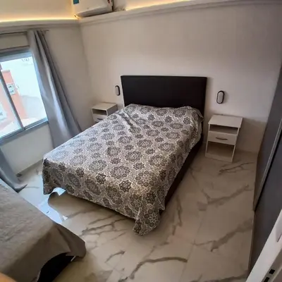 a bedroom with a bed and two tables and a window at Ein gutes Haus in Mina Clavero