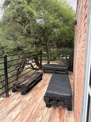 a balcony with two beds on a wooden deck at Casas de campo Traslasierra in Villa Cura Brochero