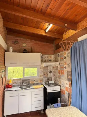 a kitchen with white cabinets and a stove top oven at Casas de campo Traslasierra in Villa Cura Brochero