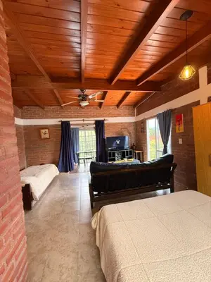 a bedroom with two beds and a couch in a room at Casas de campo Traslasierra in Villa Cura Brochero