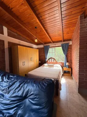 a bedroom with two beds and a wooden ceiling at Casas de campo Traslasierra in Villa Cura Brochero