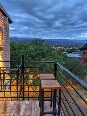 a wooden bench sitting on top of a balcony at Casas de campo Traslasierra in Villa Cura Brochero