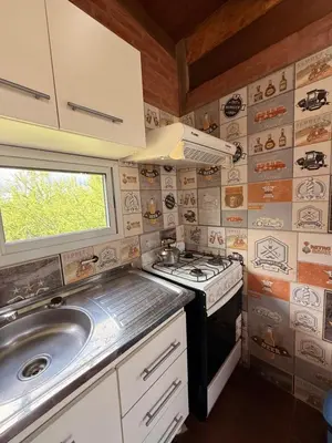 a small kitchen with a stove and a sink at Casas de campo Traslasierra in Villa Cura Brochero