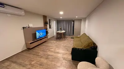 a living room with a couch and a tv and a table at Guarida Güemes Suite in Cordoba