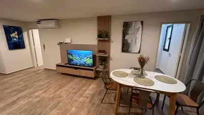 a living room with a table and a tv at Guarida Güemes Suite in Cordoba