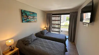 a small room with two beds and a window at Guarida Güemes Suite in Cordoba
