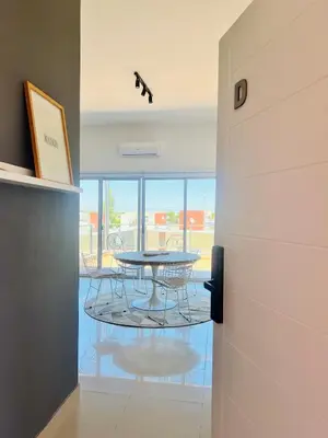 a hallway with a table and chairs in a room at Estadio Kempes Valle escondido Centro de Convenciones Amplio y Luminoso in Cordoba