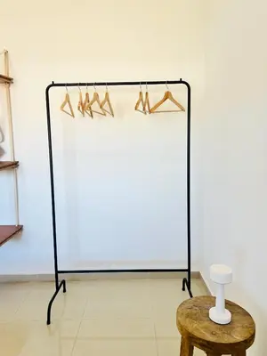 a display case with hangers and a table and a stool at Estadio Kempes Valle escondido Centro de Convenciones Amplio y Luminoso in Cordoba