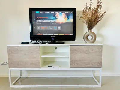 a tv sitting on top of a white entertainment center at Estadio Kempes Valle escondido Centro de Convenciones Amplio y Luminoso in Cordoba